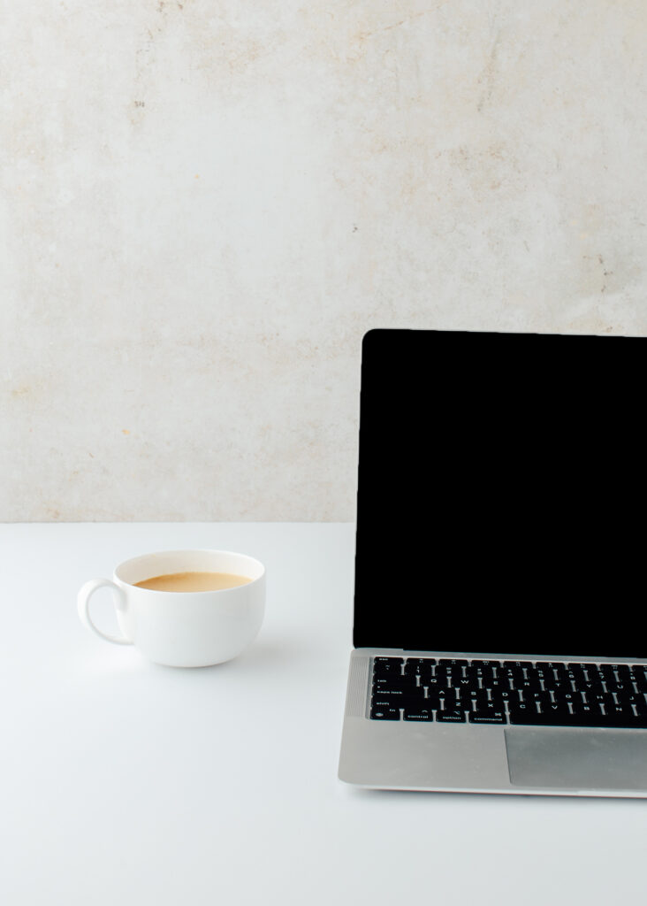 Stock image of laptop and coffee to illustrate that research is important for renovations when selling