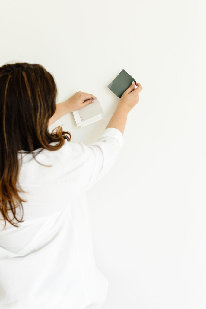 Stock image of woman holding up samples to show that others can help for renovations when selling