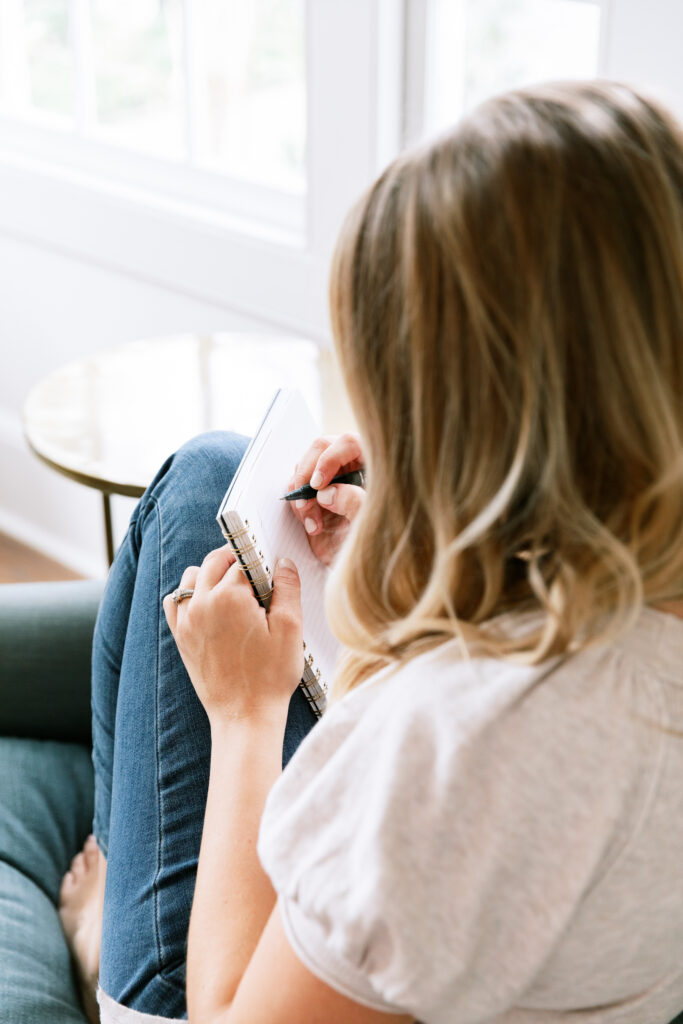 Stock image of a woman making a list to illustrate making a needs vs. wants list before renovating