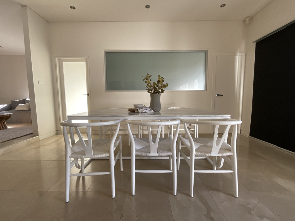 Dining area with a 6 seater dining table and white wishbone dining chairs