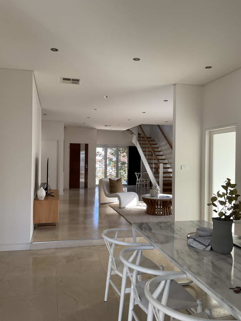 Looking from the dining area into the living room, front staircase, study nook and front door