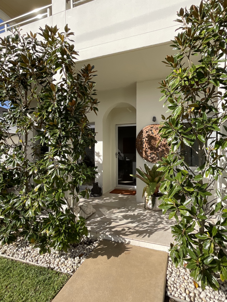 Image of the front porch of 88 Clareville Avenue including the front door and magnolia trees that provide privacy and beautiful shadiws