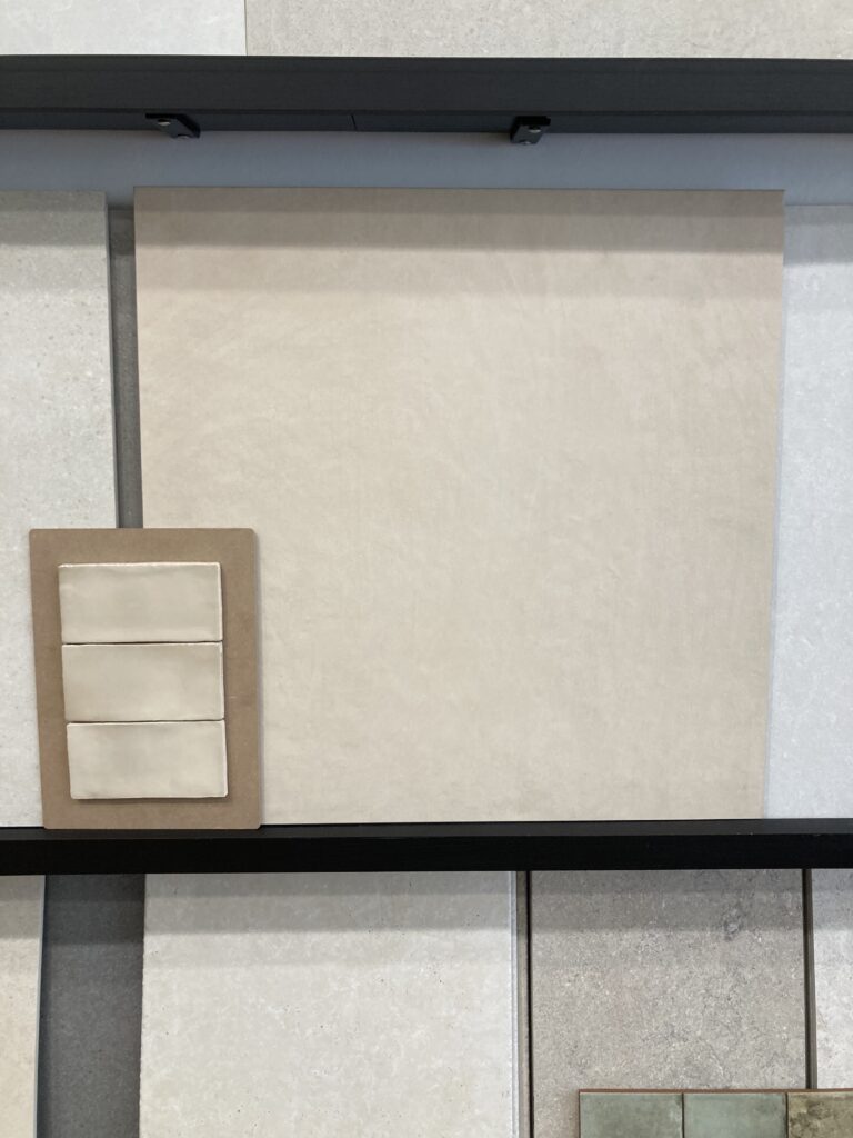 Image of the final tiles we chose in the tile shop including a large format beige tile and small glossy handmade feature tile.