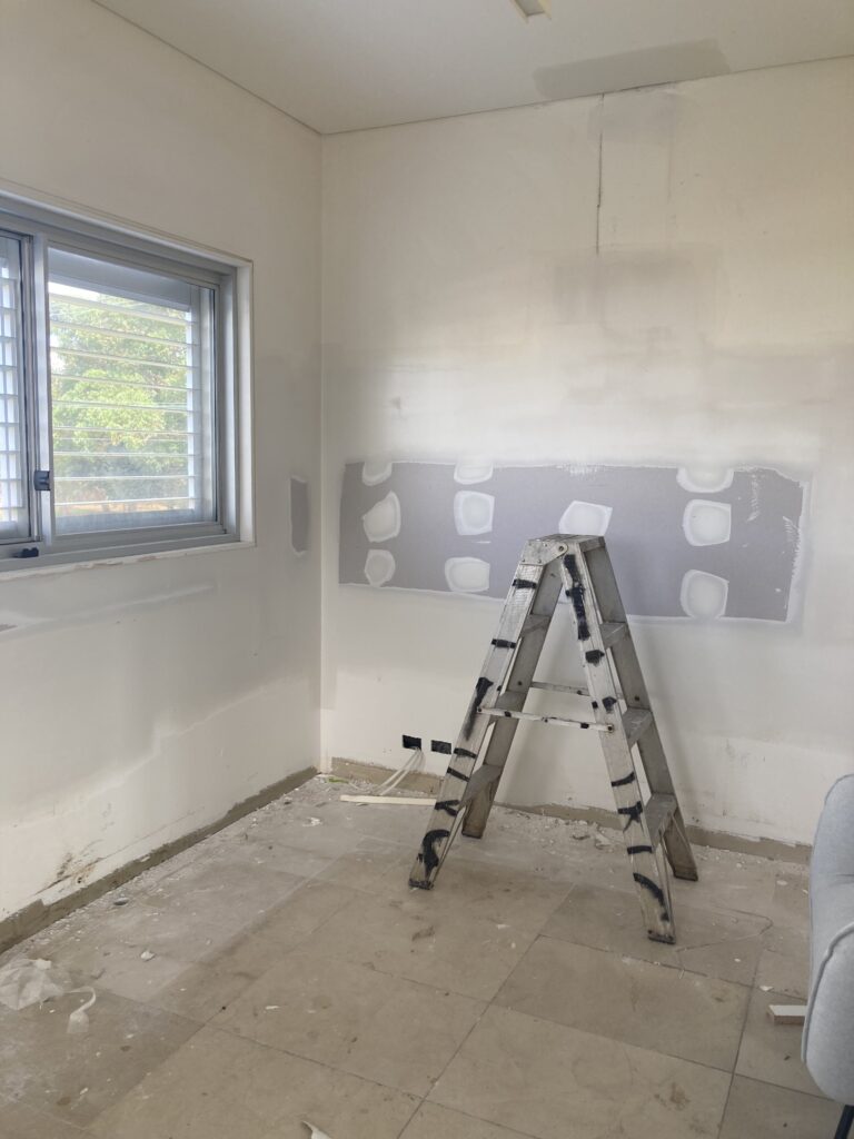 Progress of the bedroom renovation showing new gyprocked walls where the kitchen used to be