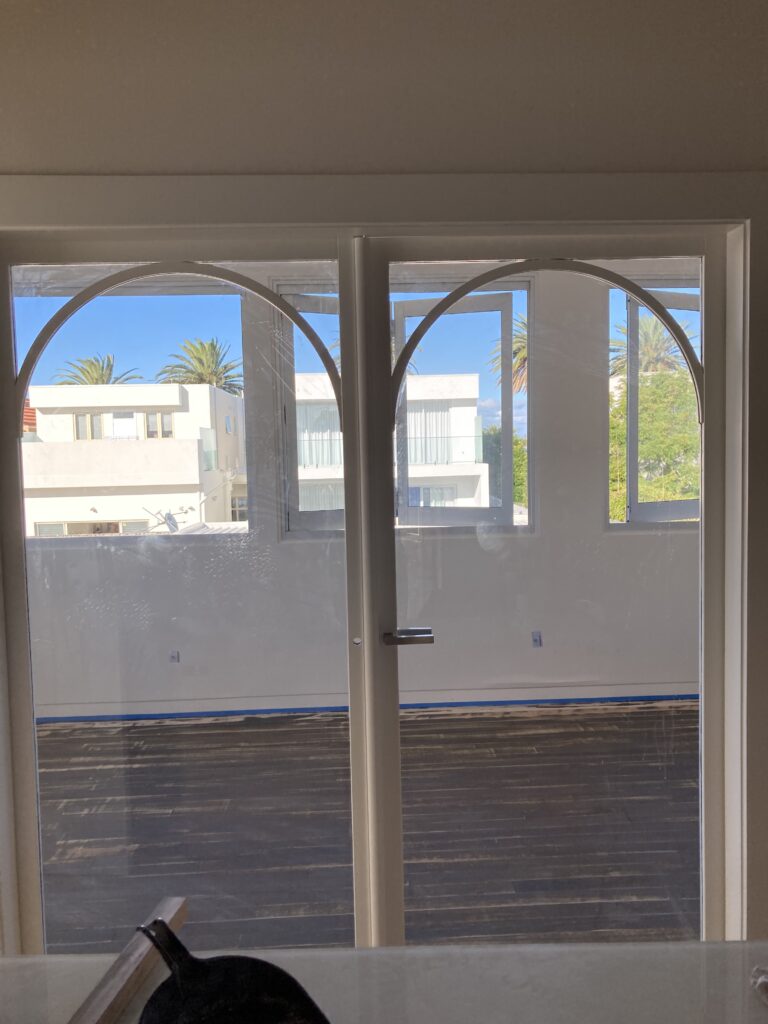 Photo of the double glass Corinthian doors after they had been painted white.