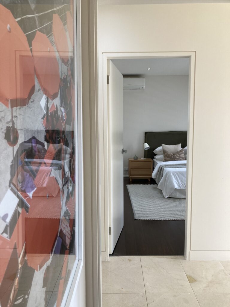 Looking into the main bedroom from the stairs landing and artwork