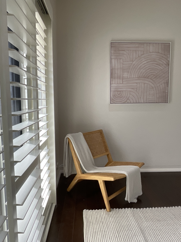 Sitting area, artwork and plantation shutters in the main bedroom