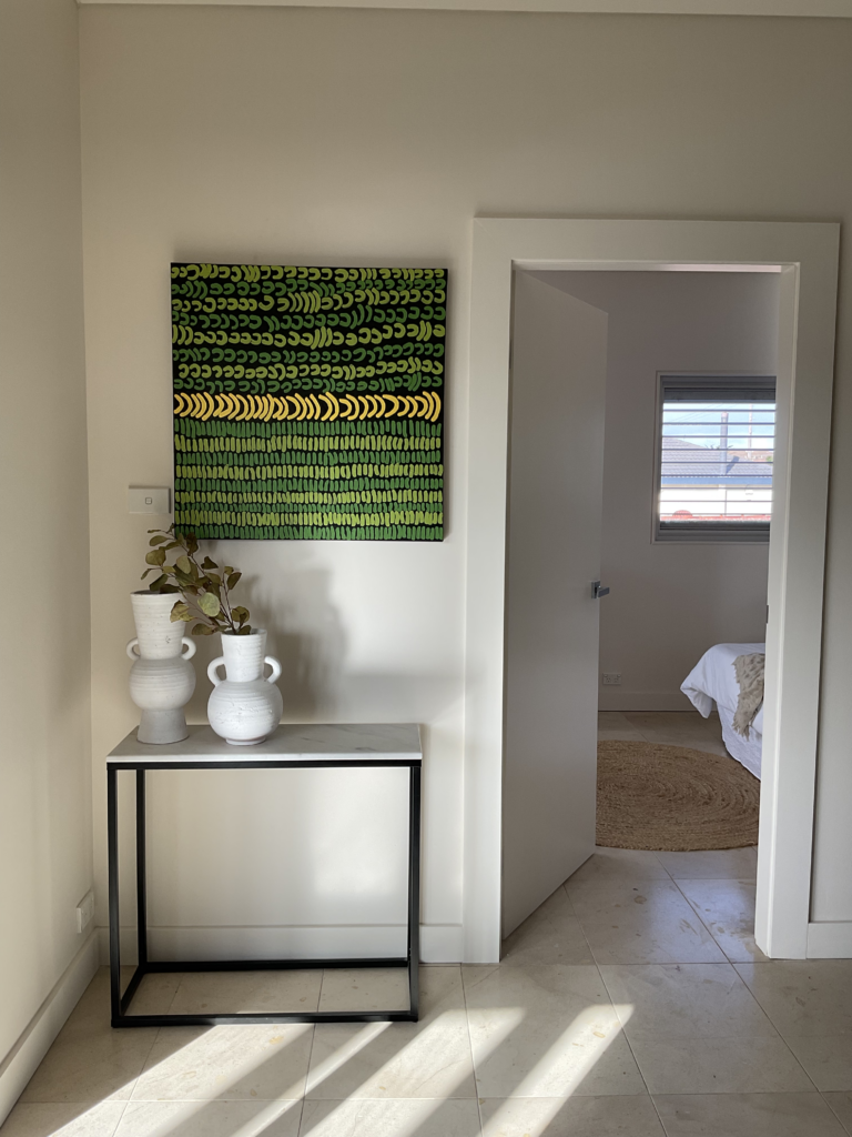 Looking into the new 5th bedroom with a console and Aboriginal artwork outside