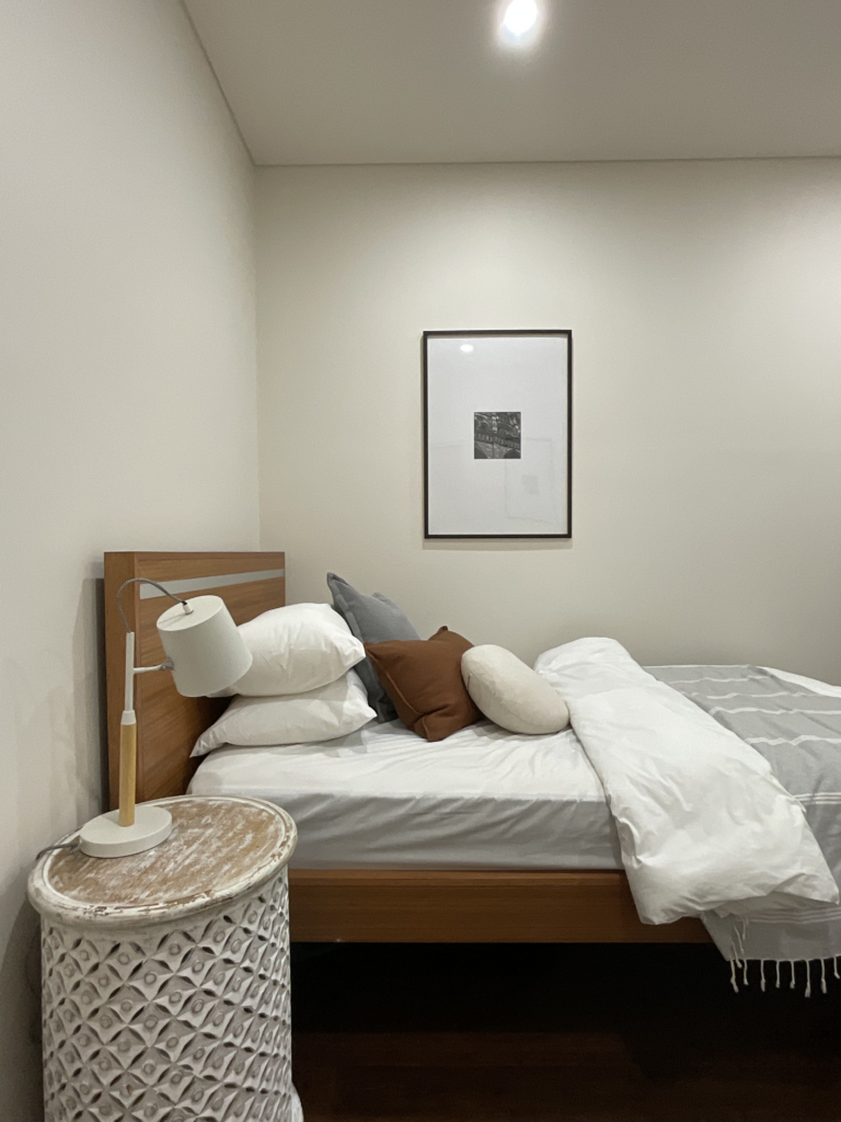 Image of the bed, side table and artwork in the spare bedroom.