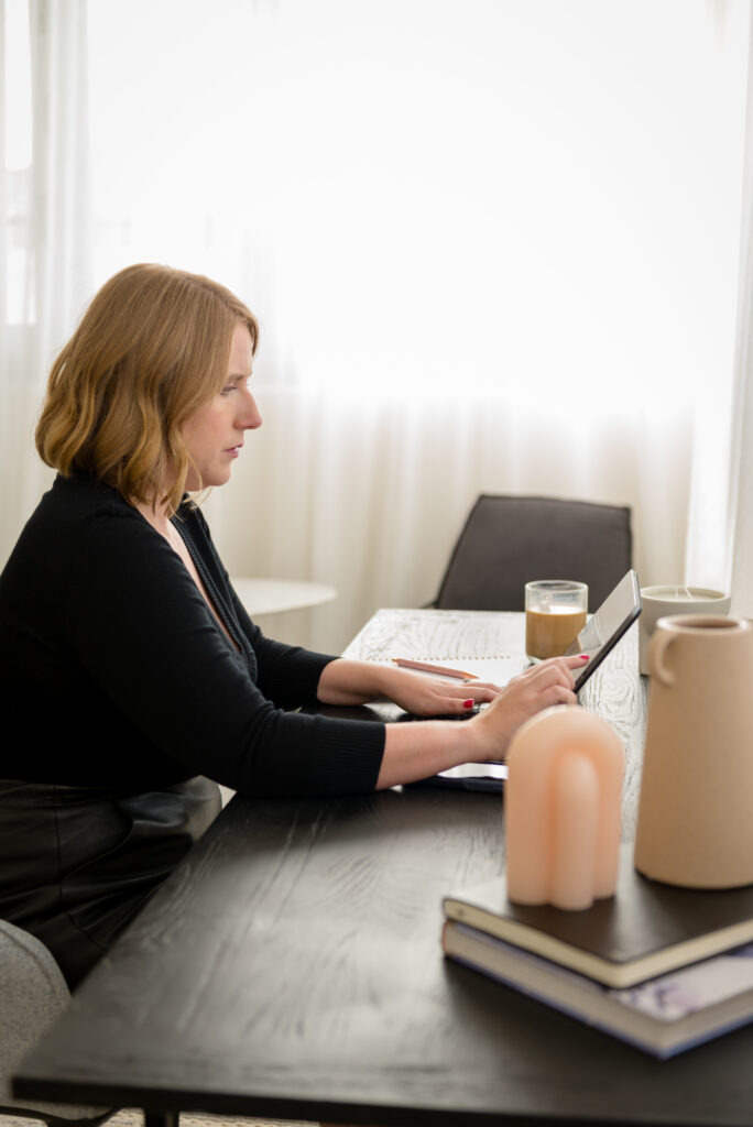 Photo of Kristen sitting at the desk in the Sandringham NSW pre-sale renovation