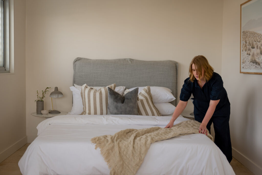 Image of Kristen straightening up the rug on the bed in the new space