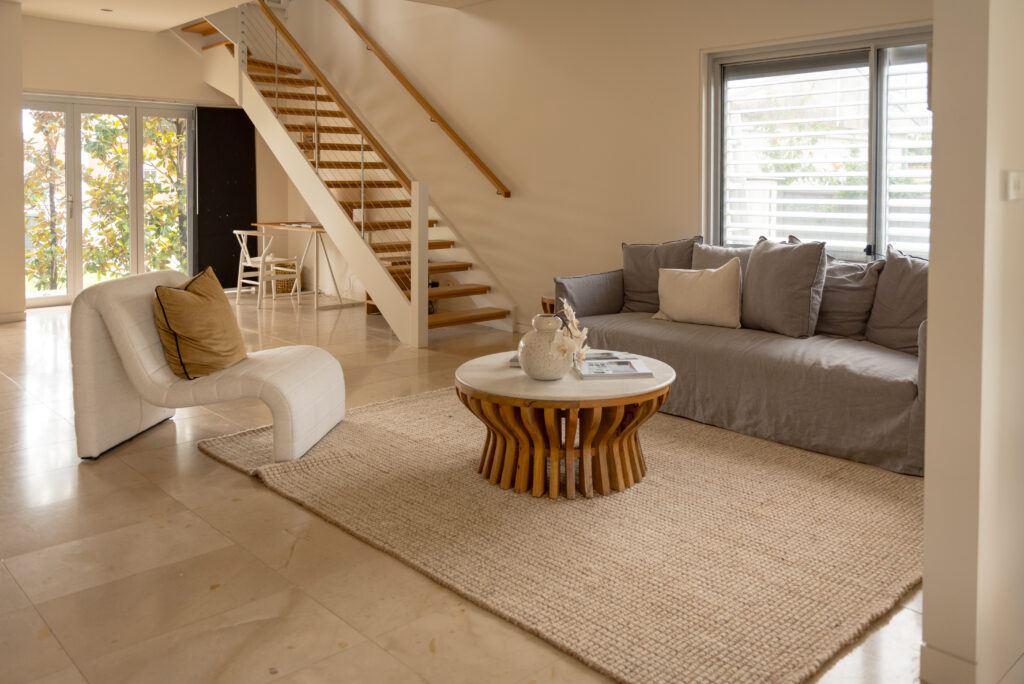 Photo of the living room of 88 Clareville Avenue with furniture styling, and the staircase and study nook in the background