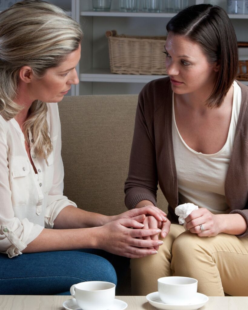 Stock image of two women grieving to illustrate the emotional aspects of a deceased estate