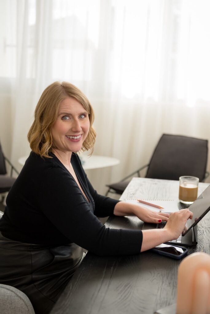 Kristen smiling at a computer to show that scheduling a free consultation is the next step to get started