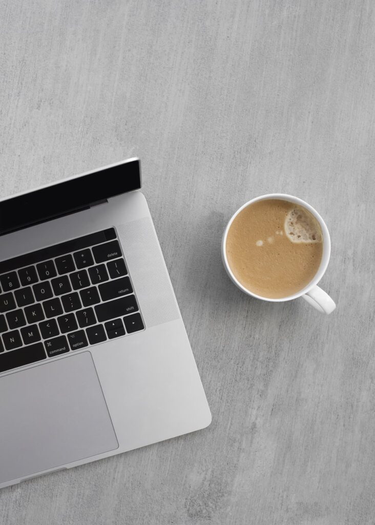 Stock image of a computer and coffee to illustrate scheduling a free pre-sale renovation consult to get started