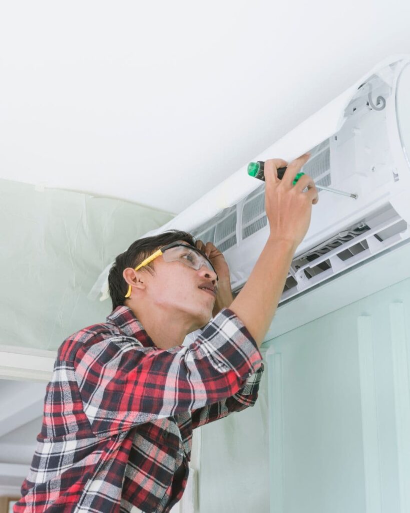 Stock image of a trade fixing aircon to show that sellers should make repairs before listing